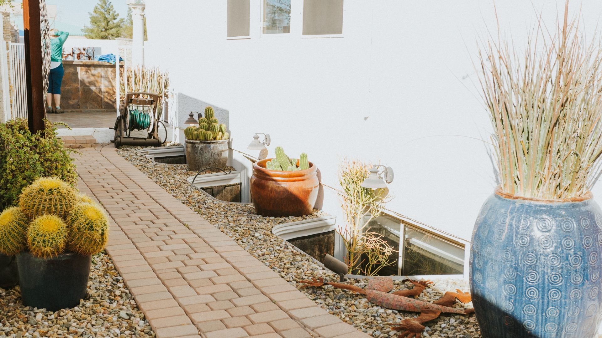 Landscaped garden path with cacti, pottery, and decorative stones